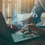 Profissional em um laptop com o símbolo DevOps e ícones de desenvolvimento e operações, ilustrando o que é DevOps