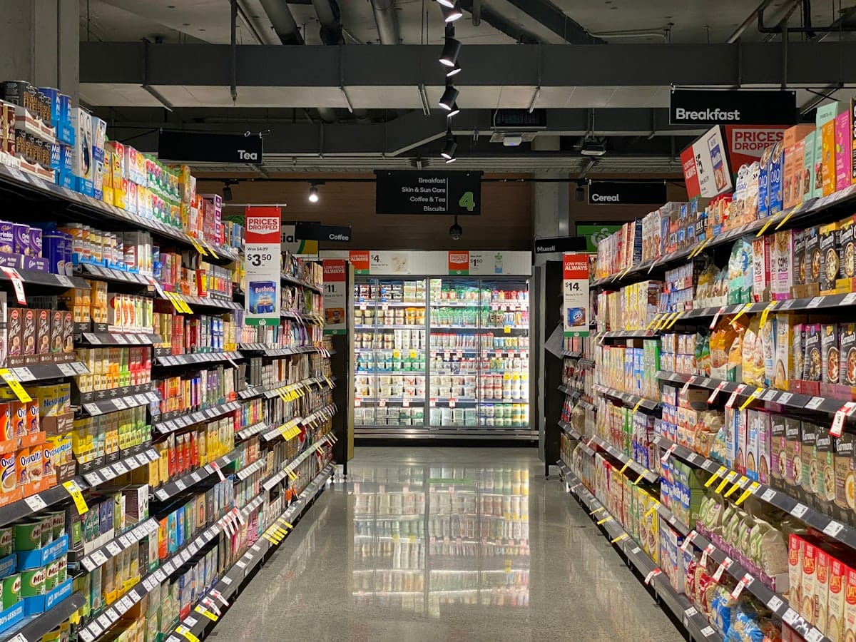 Corredor de supermercado com prateleiras cheias, resultado de uma reposição de estoque eficiente