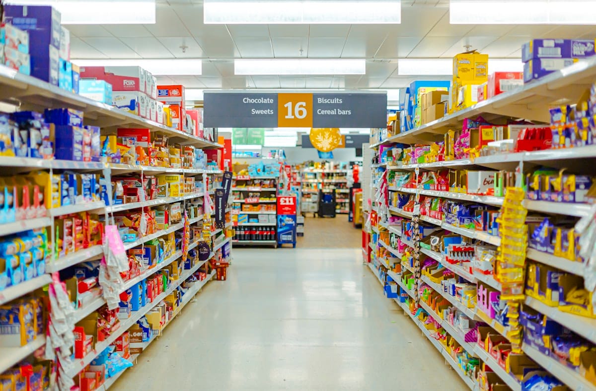 Corredor de supermercado com gondolas abastecidas, cenario da ruptura de estoque no varejo alimenticio