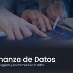 Dos personas analizando un panel de datos impreso junto a una laptop, ilustrando la gobernanza de datos