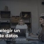 Reunión de trabajo alrededor de una mesa, con personas conversando y escuchando